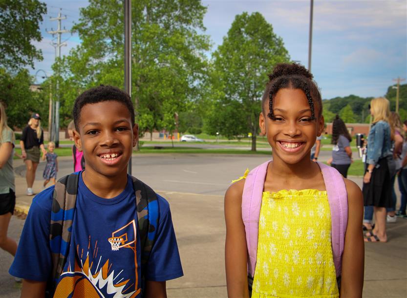 Two students smile